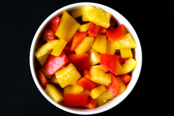 A Bowl Of Fresh Chopped Raw Uncooked Yellow And Red Peppers
