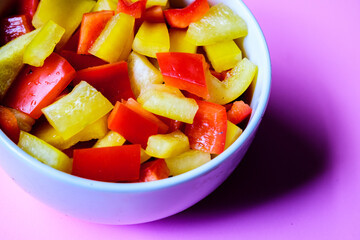 A Bowl Of Fresh Chopped Raw Uncooked Yellow And Red Peppers
