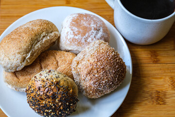 Selection Or Group Of Baked Mixed Mini Bread Rolls With A Mug Of Black Coffee Beverage