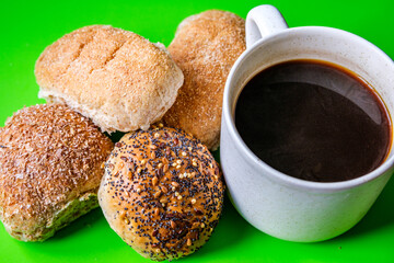 Selection Or Group Of Baked Mixed Mini Bread Rolls With A Mug Of Black Coffee Beverage
