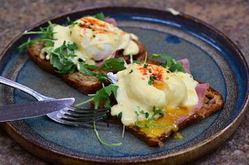 Eggs benedict with rucola and hollandaise sauce