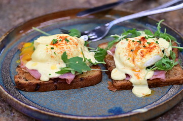Toasted bread with egg Benedict and arugula on a plate