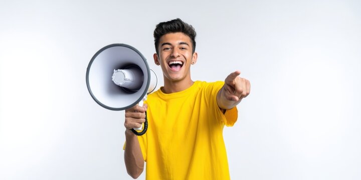 The joyful young man enthusiastically shouting into a megaphone with a smile.