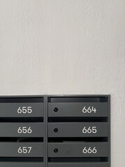 Minimalist indoor apartment mailboxes with numbers on white wall