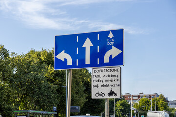 Blue urban traffic direction sign details multi-lane flow for cars, including a dedicated BUS DOP...