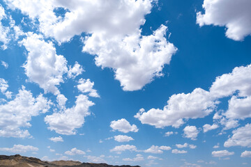 White airy clouds in a blue sky. Summer fluffy clouds, Beautiful sky with clouds, background for your projects.