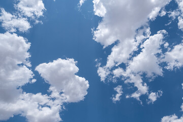 White airy clouds in a blue sky. Summer fluffy clouds, Beautiful sky with clouds, background for your projects.