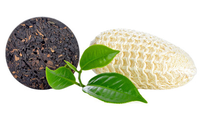 Puer tea cake and loofah sponge are presented with fresh green tea leaves on a transparent background for health and wellness.