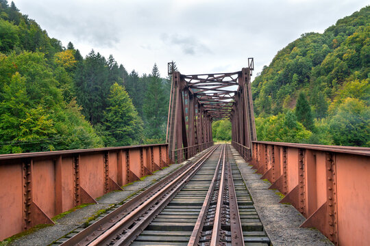 Mountain railway bridge with dual-gauge tracks connecting freight routes and passenger rail transport
