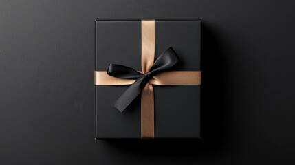 A sleek black gift box wrapped with a shiny gold ribbon and topped with a textured black bow, set against a dark background.