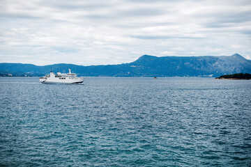 Ferry Sailing Across Calm Sea with Mountainous Coastline