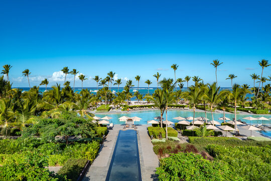 Bavaro Beach, Punta Cana: A luxurious resort pool area merges seamlessly with the stunning Caribbean beach and palm trees.