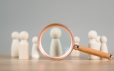 Human Resource Management or HRM. Magnifier glass focus on wooden figures intend to manager which is among staff. Talent management, Recruitment employee, Successful business team leader concept