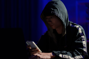 Hacker using smartphone for phishing attack and data theft in dark cyber environment