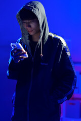 Hacker using smartphone for phishing attack and data theft in dark cyber environment