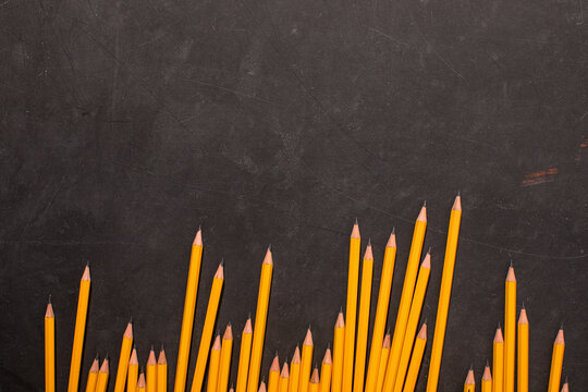 Yellow pencils overhead on blackboard