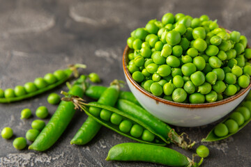 Fresh green pea pods with green peas on a wooden background. Sweet green peas. Green pea beans vegetables. Vegan. healthy vegetable. Copy space