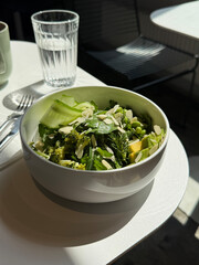 Green Salad with Cucumber, Avocado, Arugula, Spinach, Beans, and Almonds. High Fiber Healthy Food Concept. Handheld Phone Photo, Selective Focus, Harsh Sunlight, Non AI