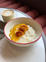 Creamy Rice Porridge with Coconut Milk, Caramelized Orange Slices, and Orange Vanilla Sauce. Modernized Traditional Recipe Concept. Hand Taken Smartphone Photo, Selective Focus, Natural Light, No AI