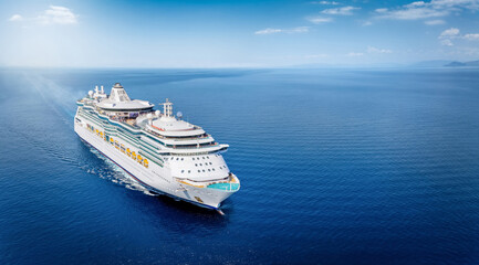 Aerial front view of a generic cruise ship sailing with speed over calm ocean with copy space