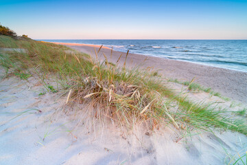 White dunes at sunrise, beach in the morning on the shore of the Baltic Sea, Dąbki, Poland.