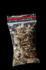 Dime bag with cannabis buds isolated on black background
