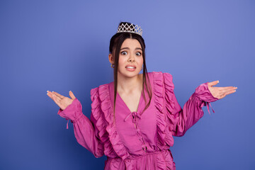 Young woman in a pink ruffled dress and tiara looking bewildered against a vibrant purple background