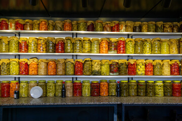 Colorful jars of assorted pickles neatly arranged on shelves