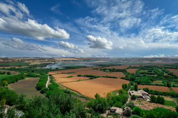 Panoramic view of Hevsel Gardens in Diyarbakir, Turkey, with lush green fields, golden crops and dramatic sky