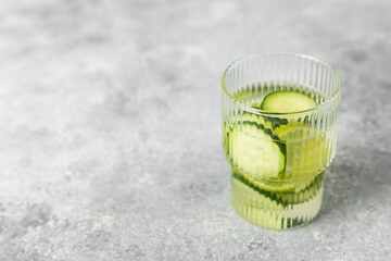 Cucumber water with lemon, lime and mint on a wooden table. Water infused with sliced...