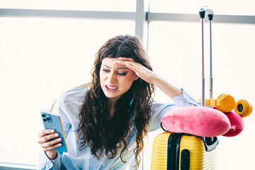 Charming woman in a casual outfit reacts to smartphone notification while waiting at the airport...