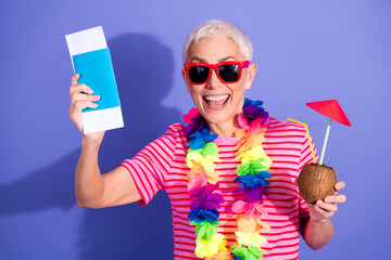 Happy elderly woman vacationing with sunglass, holding drink and travel document, enjoying vibrant...