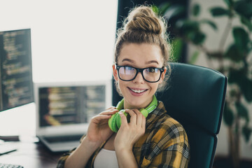 Young female software developer working in modern workspace with coding on computer screens and a...