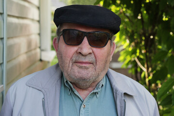 Portrait of an old handsome pensioner in the garden.