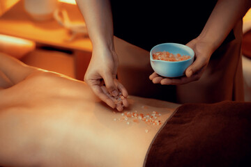 Woman customer having exfoliation treatment in luxury spa salon with warmth candle light ambient....