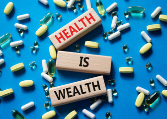 Health is Wealth symbol. Concept word Health is Wealth on wooden blocks. Beautiful blue background...