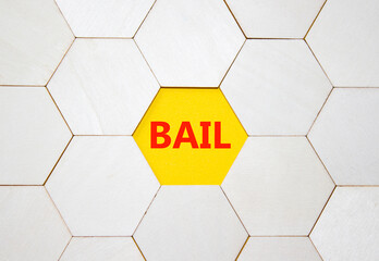Bail symbol. Concept word Bail on wooden cubes. Businessman hand. Beautiful yellow background....