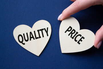 Price or Quality symbol. Concept word Price or Quality on wooden hearts. Businessman hand....