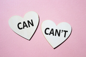 Can or Cant symbol. Concept word Can or Cant on wooden hearts. Beautiful pink background. Business...