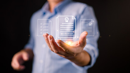 A businessman holds glowing digital document icons, representing certification, compliance, digital records, quality assurance, verified documentation, and modern data management systems.
