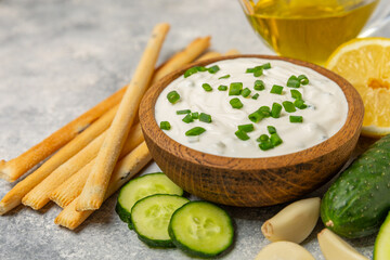 Cucumber sour cream tzatziki sauce on a wooden table.Tartar sauce. Traditional delicious appetizer....