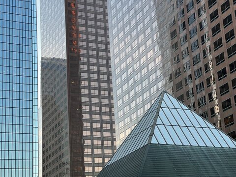 LOS ANGELES, CA, JAN 2, 2025: urban skyline with modern glass and concrete towers surrounding a distinctive glass pyramid structure, creating geometric contrasts between reflective surfaces