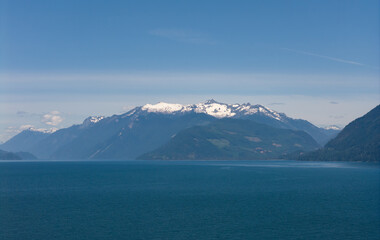Snow-Capped Mountains and Blue Lake in BC, Canada Under a Clear Sky