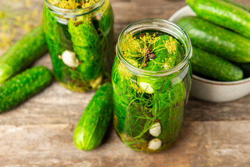 Freshly-salted homemade cucumbers in a jar on a wooden background. pickled cucumbers with...