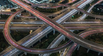 Aerial Night View of Complex Highway Interchange with Moving Car Lights in Urban City