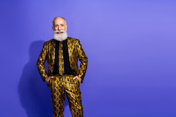 Confident senior man in an extravagant golden suit posing against a vibrant purple background