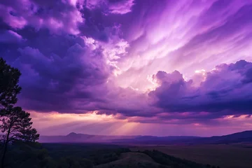 Fototapeten A scenic landscape of purple clouds and mountains at sunset creates a dramatic and beautiful view of nature © Roushon