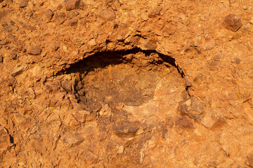 Circular hollow formed in a rock face in late afternoon golden light along the Echo Canyon Trail, Phoenix