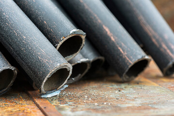 Cut steel pipes on a corroded metal surface