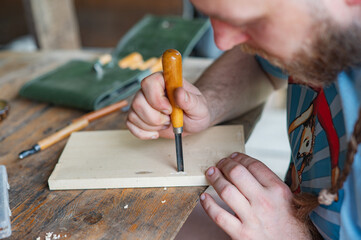 A man carving wood with chisels. Creativity, hobby